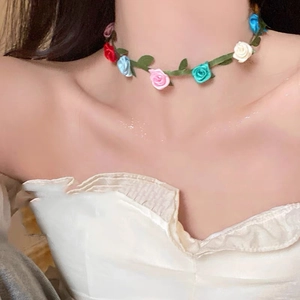 Detailed view of a sweet floral choker with colorful roses on a green vine ribbon