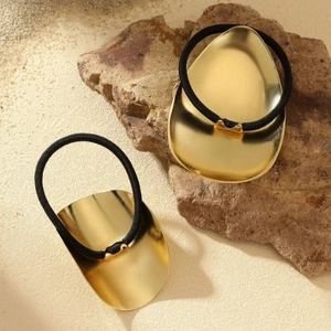 Minimalist oval gold metal hair ties with high elasticity black bands on natural rock