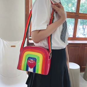 Close-up of rainbow heart crossbody bag showing glossy patent material and woven strap