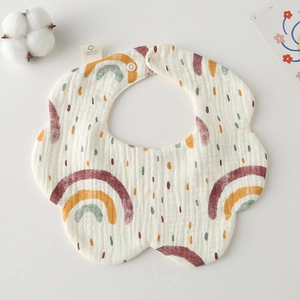 Detail of petal-shaped cotton baby bib featuring rainbow patterns and adjustable snaps