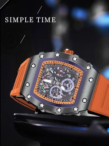 Primer plano de reloj automático de tonel con correa de goma naranja y esfera de esqueleto