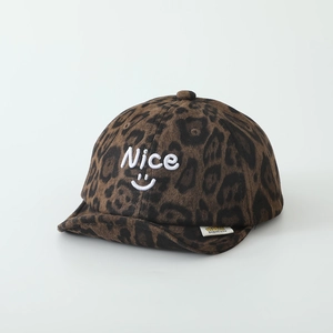 Detailed close-up of leopard print baby cap with soft brim and embroidered smile logo