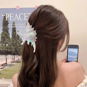 Iridescent conch shell acrylic hair claw clip worn on hair for beach vacation style