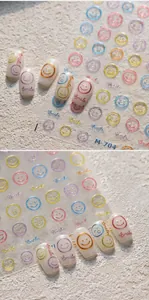 Macro detail of colorful glitter smiley face nail stickers with 'Smile' text on nails