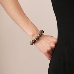 Detail of leopard print acrylic beads bracelet with gold spacers on model wrist