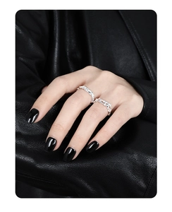Detail of two S925 sterling silver rings with irregular lava texture on fingers