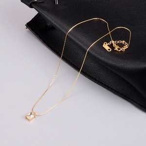 Macro detail of gold-plated necklace with rectangular cubic zirconia and K18 tag