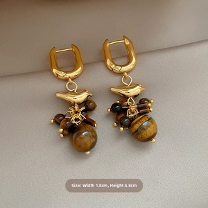 Detail view of 18k gold bird earrings with tiger eye tassels and 4.8cm height dimensions