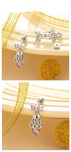 Detailed close-up of badminton-shaped silver earrings with pink bow zircons and gemstones