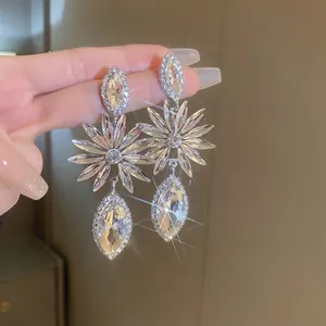 Sparkling silver needle floral drop earrings with marquise-cut rhinestones held by hand