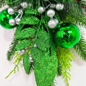 Guirlande d'escalier de Noël avec aiguilles de pin vertes, feuilles pailletées et boules
