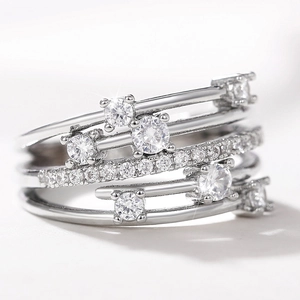 Detalle del anillo cruzado plateado con micro-pavé de circonitas y cristales engarzados