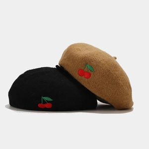 Classic wool beret hats in black and camel featuring delicate cherry embroidery detail