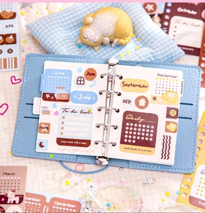 Close-up of blue PU leather binder with June and September themed planner stickers