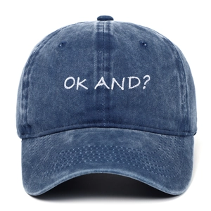 Close-up of white OK AND? embroidery on washed blue denim baseball cap