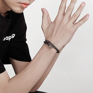 Minimalist black nail-shaped steel wire bracelet with twisted metal texture on wrist
