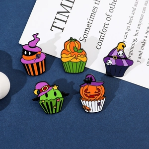 Macro shot of Halloween cupcake enamel pins with pumpkin, witch hat and skull designs