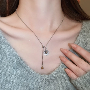 Detail of 18k gold plated sun pendant with tiger eye stone on a beaded chain necklace