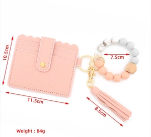 Detailed size view of pink silicone bead keychain with faux leather card holder and tassel