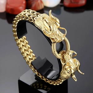 Gros plan du bracelet tête de dragon plaqué or 18K avec chaîne tressée sur support noir