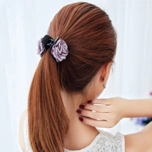 Elegant medium hair claw clip featuring purple fabric roses on a black floral hair accessory