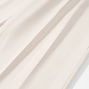 Detailed close-up of smooth cream beige fabric texture and soft drape on business suit
