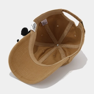 Khaki cotton baseball cap with black plush ball detail and adjustable strap