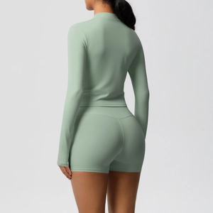Back view of mint green high-waisted yoga shorts and fitted long-sleeve athletic top