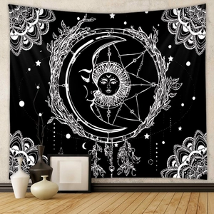 Detail of bohemian sun and moon tapestry with mandala pattern and feather accents on wall