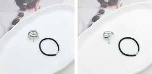 Minimalist silver curved ponytail hair hook set with black elastic band on white tray