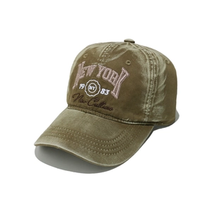 Close-up of New York embroidery on olive green velvet baseball cap with 1983 detail