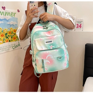 Front view of a gradient backpack with butterfly and moon patterns on a nylon surface