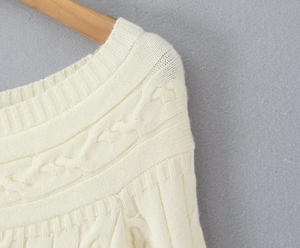 Détail du col en tricot torsadé et de la texture douce du pull couleur crème