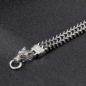 Détail macro du bracelet tête de loup viking pour homme avec maillons de chaîne tressée