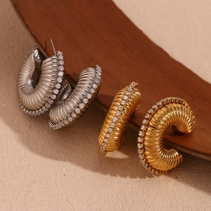 Detailed macro shot of 18K gold and silver plated ribbed hoop earrings with cubic zirconia