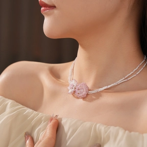 Close-up of double-layer beaded bamboo link necklace with pink flower charms on neck