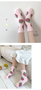 Detailed knit texture of pink coral fleece socks featuring cute strawberry patterns