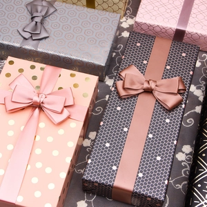 Elegant gift boxes with geometric gold foil patterns and silk ribbons in various sizes