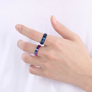 Macro shot of faceted titanium steel rings in deep blue and iridescent multi-color finishes