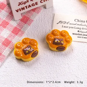 Detailed macro view of an orange cat paw resin charm for DIY crafts and jewelry making