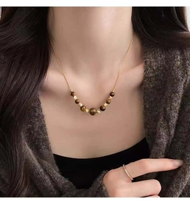 Elegant brown tiger eye bead necklace on gold chain worn with cozy autumn knitwear