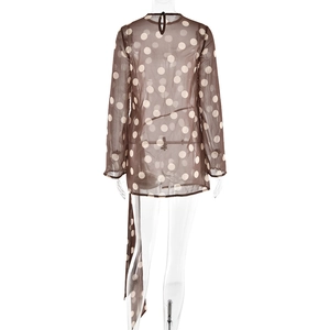 Détail d'une robe marron à pois blancs avec dos nu en goutte d'eau et ruban de serrage long