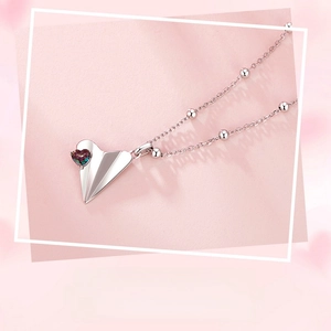 Close-up of S925 sterling silver paper plane pendant with iridescent heart gemstone