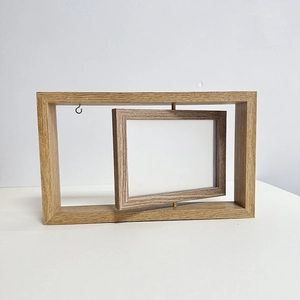 Close-up of a double-sided rotating wooden photo frame with light natural grain finish