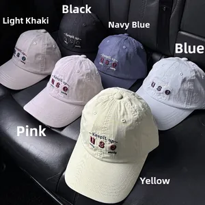 Flat lay of washed cotton baseball caps in six colors with vintage letter embroidery