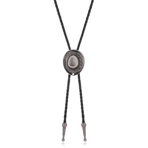 Close-up of antique silver cowboy hat pendant with black woven bolo tie leather cord
