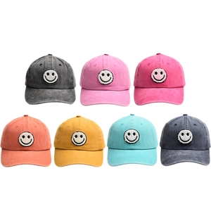 Multi-color array of washed cotton baseball caps with embroidered smiley face patches