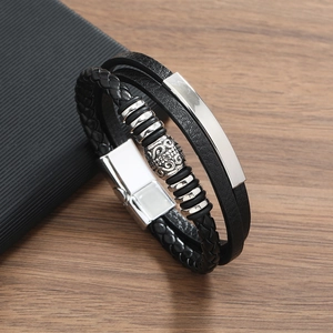 Detail of multi-layer black braided leather bracelet with silver metal beads and magnetic clasp