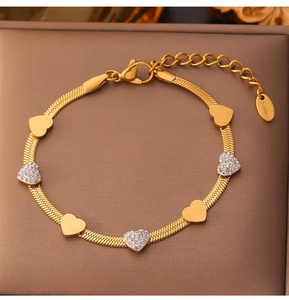 Detail of heart bracelet with gold snake chain and white zircon inlay on jewelry box