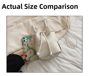 Mini hand-woven white bucket bag shown next to phone to display its small size